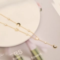 Elegante goldene Doppelhalskette mit schwarzem Mond und weißen Sternanhängern auf Teller - Stil 2 Stern und Mond