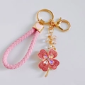 Close-up of pink rhinestone four-leaf clover keychain with woven PU leather strap and gold ring - Heart Strap / Pink