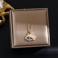 Golden Evil Eye necklace with blue resin eye and white zircon pavé on a jewelry box - A9-Gold