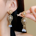 Detail of vintage hollow gold earrings featuring white pearls worn by a model - 7# Silver Earring Post - Gold - White - Pearl Tassel