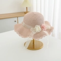Close-up of pink straw sun hat with fabric roses, lace brim, and pearl details - Hat / Pink