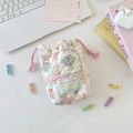 Close-up of pink quilted drawstring pouch with floral pattern and Sorakka Studio label - Patchwork Berry