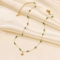 Close-up of gold starfish shell necklace with green beads on silk background - Green Bead Seashell Necklace (H6146)