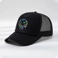 Close-up detail van de regenboog smiley print op de zwarte mesh trucker pet - Zwart / Eén maat