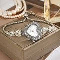 Detail of luxury heart-shaped quartz watch with crystal inlay on a champagne jewelry box - Silver White