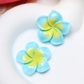 Macro view of blue and yellow gradient resin frangipani charms with glossy finish - L Blue
