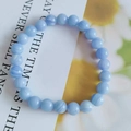 Macro detail of 8mm blue cat eye stone beads with natural striped texture on a card - Blue Stripe