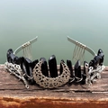 Detail of black crystal crown featuring a silver crescent moon and branch elements - Black