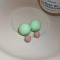 Gros plan de boucles d'oreilles bicolores vert clair et vieux rose sur plateau - Boucles d'Oreilles Clous Color Block à Double Boule Verte et Rose