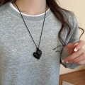 Detail view of a vintage black heart pendant necklace on a rope chain worn by a model - 22# Necklace - Black - 3D Heart