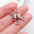 Silver cylindrical magnetic jewelry clasps with spring buckles shown on a fingertip - Antique Silver Cylindrical Double-Headed Magnetic Clasp / 26x7mm