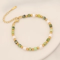 Detailed macro view of square green natural stones and white pearls on a beaded bracelet - Chrysoprase