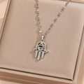 Detailaufnahme des Hamsa-Hand-Anhängers mit grünem Stein auf einer Schmuckschatulle - Silber Weißer Zirkon