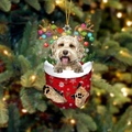 Süßer Hund mit Rentiergeweih in einem roten Weihnachtsstrumpf-Anhänger mit goldener Kordel - Braun-weißer Welpe