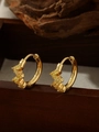 Detailed close-up of 18k gold-plated hoops with yellow zircons on dark wood surface - ZHE1534 Style - Yellow Rhinestone / 18K Gold