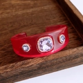 Detail einer roten transparenten Harzmanschette mit fliederfarbenen Kristallen - Roter Armreif Mit Hellviolettem Stein