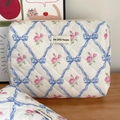 Détail de la trousse de toilette matelassée avec roses, rubans bleus et étiquette tissée - Fleur de Nœud Bleue (Pochette)
