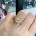 Silberring mit gelbem Zirkon im Kissenschliff und Halo-Design in blumiger Umgebung - Gelber Zirkonia-Ring
