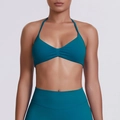 Detail view of teal halter neck sports bra with subtle pleat design and high waist leggings - Malachite green