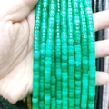 Macro shot of natural green translucent cylindrical spacer beads for DIY jewelry making - Malay Jade