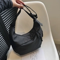 Black nylon crescent shoulder bag with woven zipper and adjustable strap detail - Black
