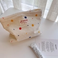 White canvas cosmetic bag with colorful embroidered dots on a bright minimalist desk - White with Colorful Polka Dots