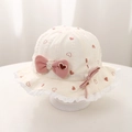 Detailed close-up of a baby bucket hat with red hearts, pink bow and lace trim - 48cm (5-18 Months) / Off-white with Pink Heart Print