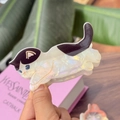 Pince à cheveux chat en acétate avec motifs blancs irisés et taches violettes - Chat qui joue