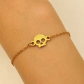 Close-up of a gold stainless steel bracelet with a skull pendant on a model wrist - Skull Pendant Style (3681) / Gold