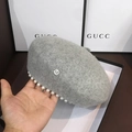 Close-up of a grey wool beret featuring pearl rim decoration and a silver M metal logo - Gray