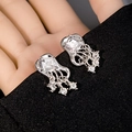 Macro shot of silver jellyfish earrings with cubic zirconia on black fabric - Silver Fluid Jellyfish