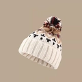 Detaillierte Nahaufnahme der Strickmütze mit Webstruktur und buntem Bommel für den Winter - M / Weiß