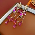 Elegant gold earrings with pink crystal tassels and pearls displayed on a leather box - Pink (925 Sterling Silver Earring Post)