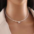 Shell beaded necklace with gold heart and letter N pendant worn on neck - Letter N
