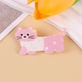 Broche de gato rosa en acrílico con detalle de flor amarilla sobre fondo beige - Gato Rosa