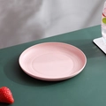 Pink round plastic plate for snacks and fruits on a dark green table background - Pink-Shallow Round Dish