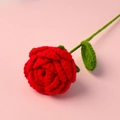 Close-up detail of a handmade knitted red rose showing yarn texture and green leaves - Red Rose Bouquet (Dark Green Leaves)