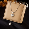 Minimalist silver snake chain necklace with dual heart pendants on gold jewelry box - Silver Style (N2703)