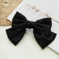 Grande barrette à nœud en satin noir avec fermoir à ressort sur fond blanc - Noir