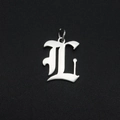 Macro-opname van zilveren gotische letter L-hanger met gepolijste afwerking en ringetje - Letter L