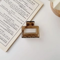 Square amber hair claw clip with spring and teeth on a white book aesthetic background - Glossy Tea Brown