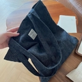 Detail of dark blue denim tote bag featuring white woven label and diagonal twill texture - Solid Denim Blue Style