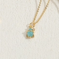 Golden rocket necklace with light blue gemstone pendant and zircon on beige surface - Rocket Shape Light Blue (XL2629)