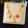 Close-up of gold-plated bracelet with red enamel hearts and floral charms on a beige box - Pendant Necklace (N3792)