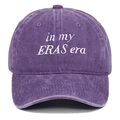 Detailed close-up of white 'in my ERAS era' embroidery on a washed purple cotton baseball cap - Purple