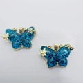 Chic butterfly pendant featuring blue glitter wings and gold-tone finish with gemstones - Blue