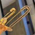 Macro shot of gold decorative pin with sparkling rhinestones used for waist adjustment - Golden Brooch with Double Row Rhinestones on Black Base (7.5cm)