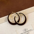 Macro detail of retro C-shaped velvet earrings with gold-toned metal and flocked texture - Brown