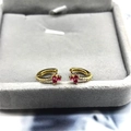 Macro detail of gold huggie earrings with ruby-red flower and white zircon accents - Gold / Rose Red Zircon