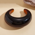 Vista detallada de un brazalete abierto de resina traslúcida marrón oscuro sobre fondo beige - Café Traslúcido